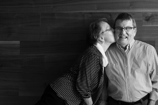 Mature woman kissing mature man on cheek