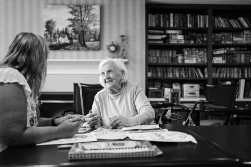 Elderly woman at table with another woman