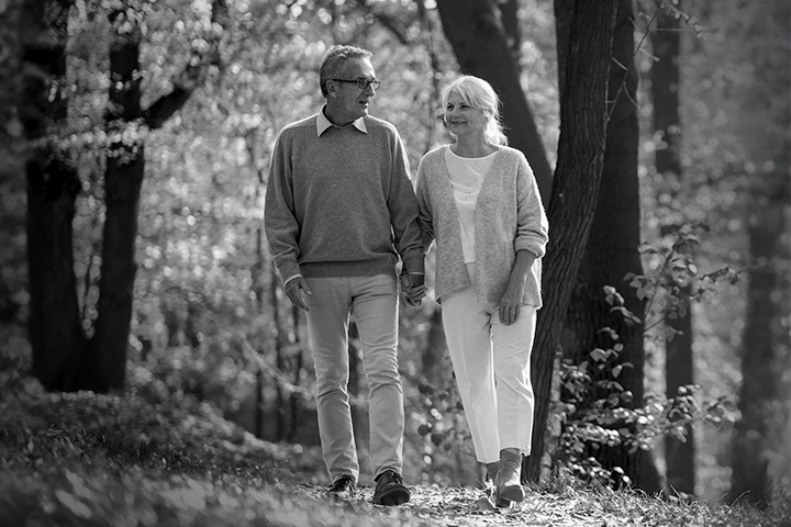 senior couple walking through the woods hand-in-hand in the Fall talking about what legacy they'd like to leave.