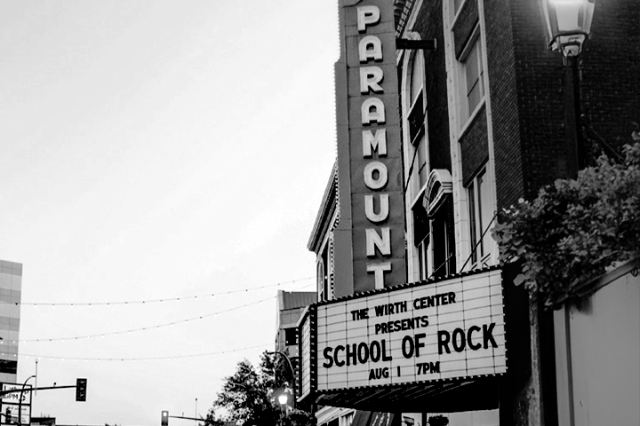 Black and white photo of the Paramount theater with a marquee for School of Rock at 7 PM.