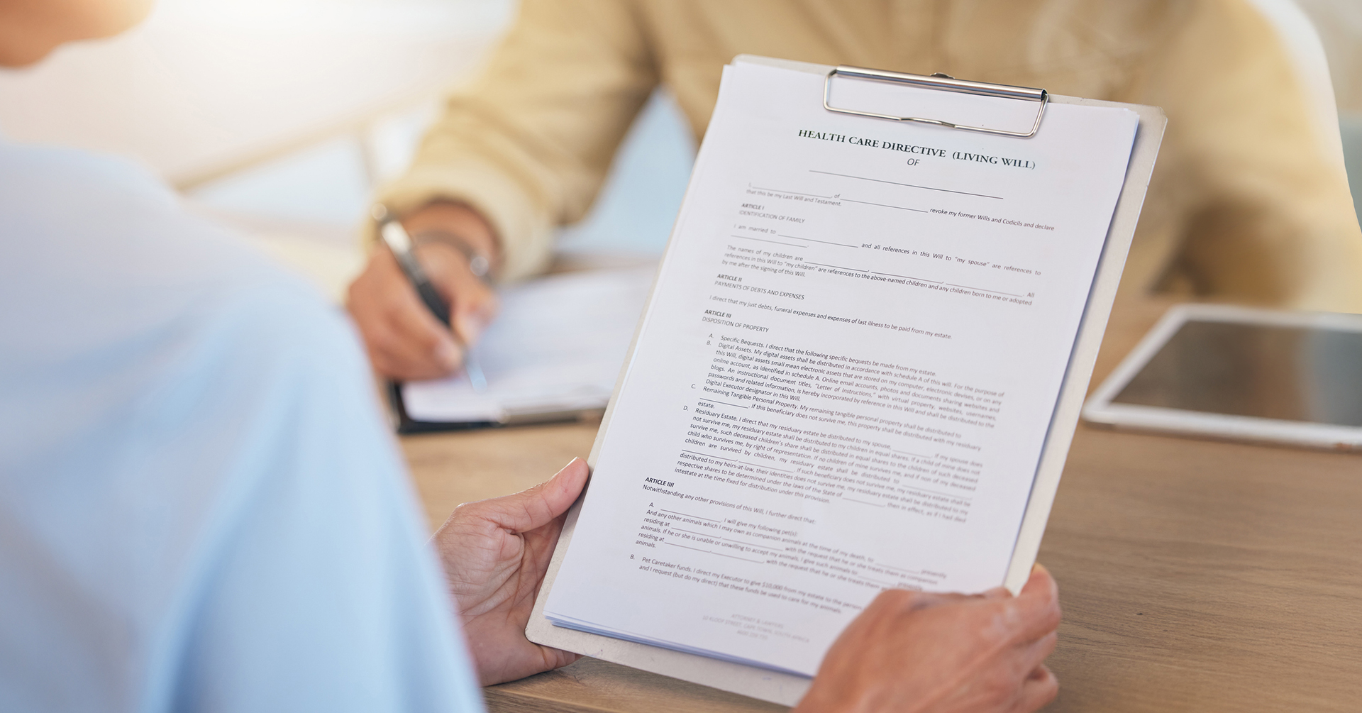 an older adult woman completing a form for her Health Care Directive (Living Will)