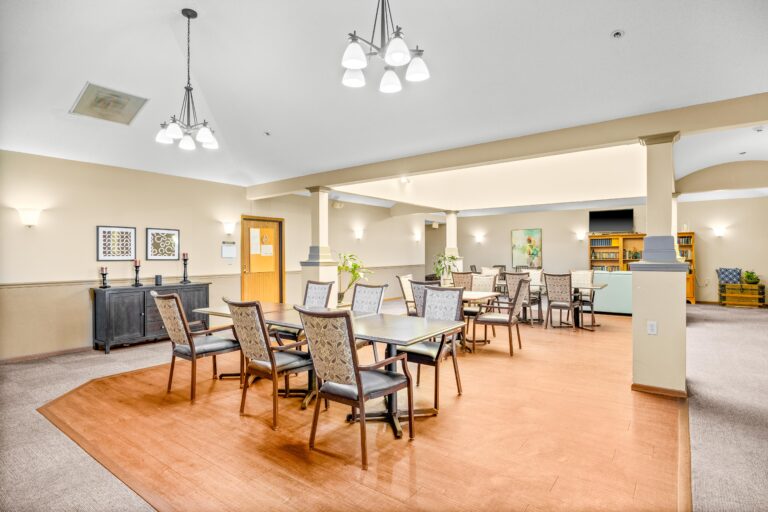 Well-lit dining area with multiple tables and chairs, modern decor, and wall art in a spacious room.