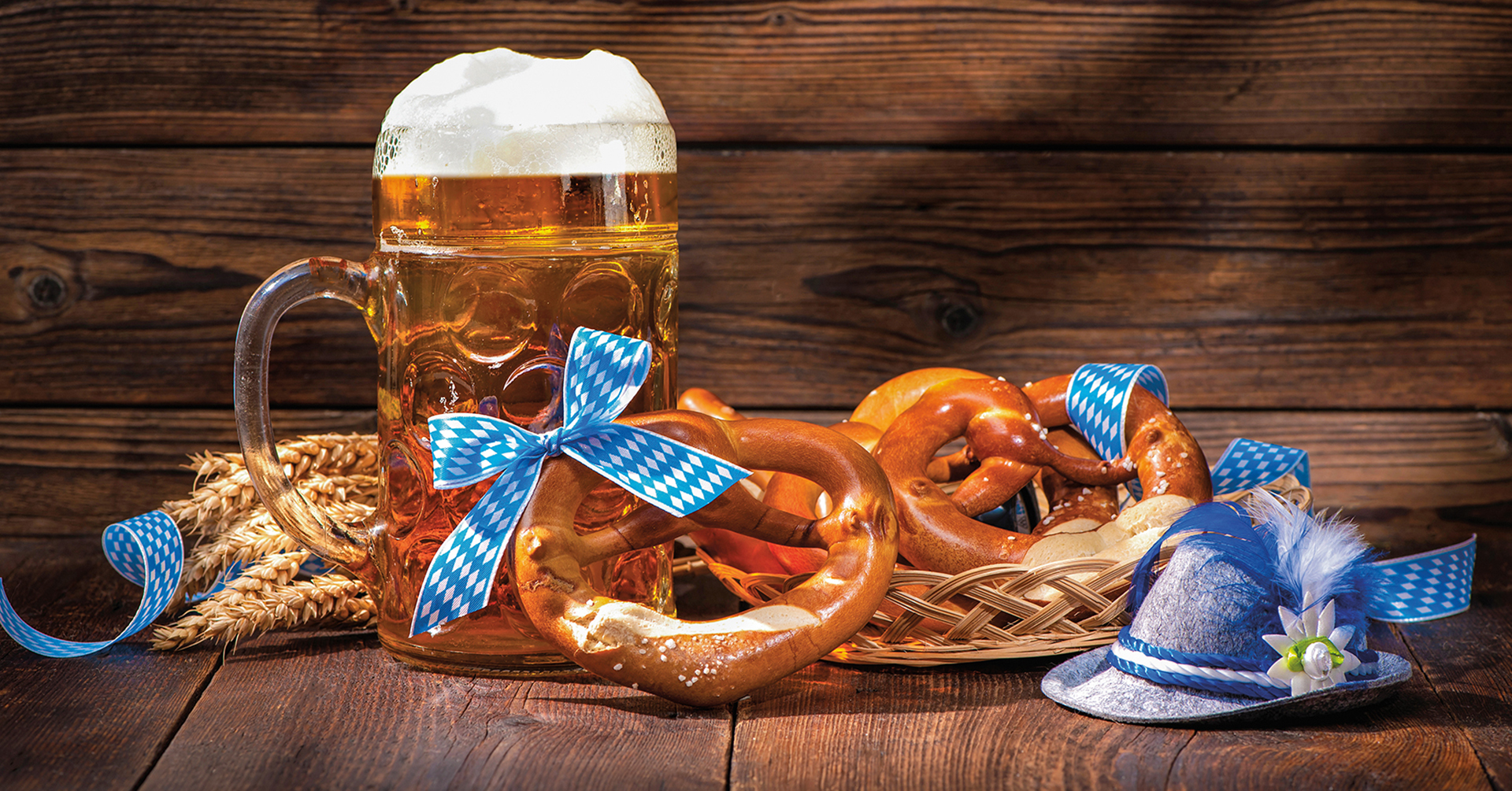 Oktoberfest Image Oktoberfest display with a glass mug of beer and large pretzels decorated with blue and white ribbon and a blue hat