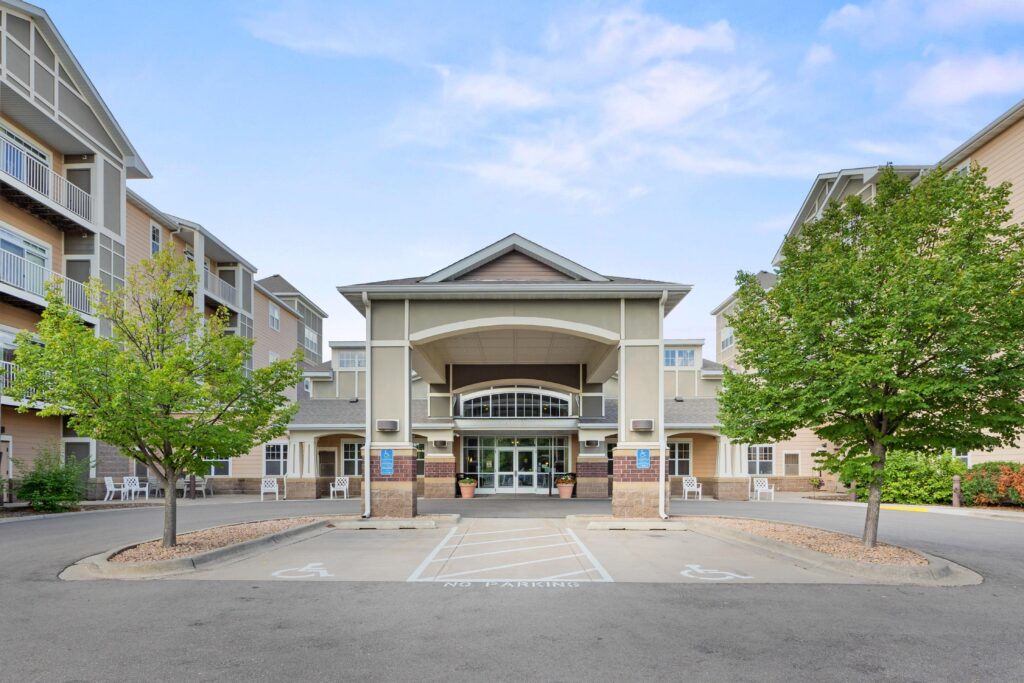 Front view of a Ecumen Seasons at Maplewood building with trees, accessible parking, and the community main entrance visible in front.