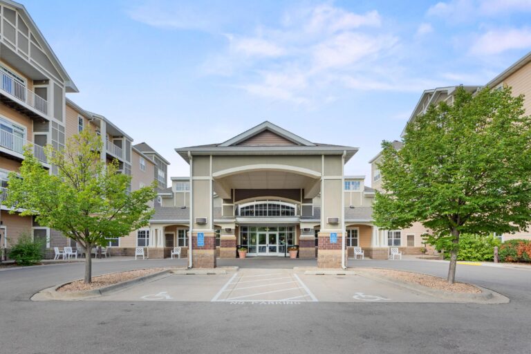 Front view of a Ecumen Seasons at Maplewood building with trees, accessible parking, and the community main entrance visible in front.