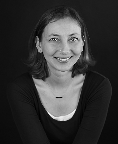 Professional black and white portrait of Nicole Anderson, wearing a dark sweater and necklace