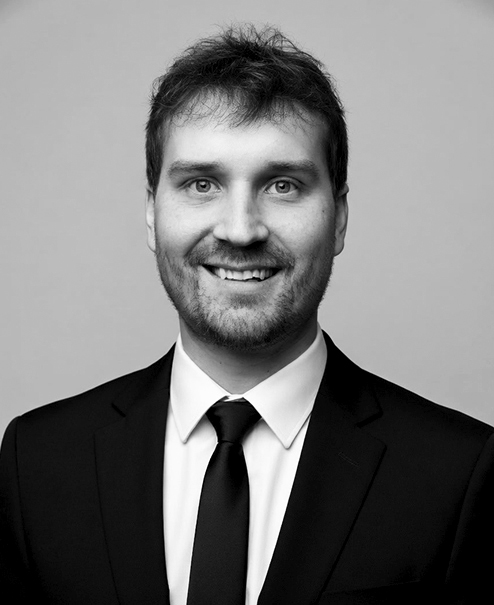 Professional black and white portrait of Justin Boldt wearing a jacket and tie