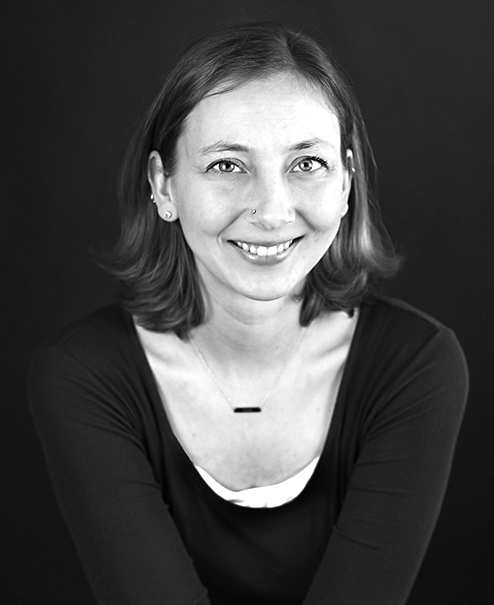 Professional black and white portrait of Nicole Anderson, wearing a dark sweater and necklace
