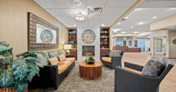 Cozy lobby with wicker sofas and a stone fireplace. Earth tones dominate.