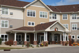 Main entrance of a three-story apartment building, featuring a large portico
