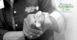 A black and white close-up of two people holding hands, with text announcing Teepa Snow’s Positive Approach to Dementia Care