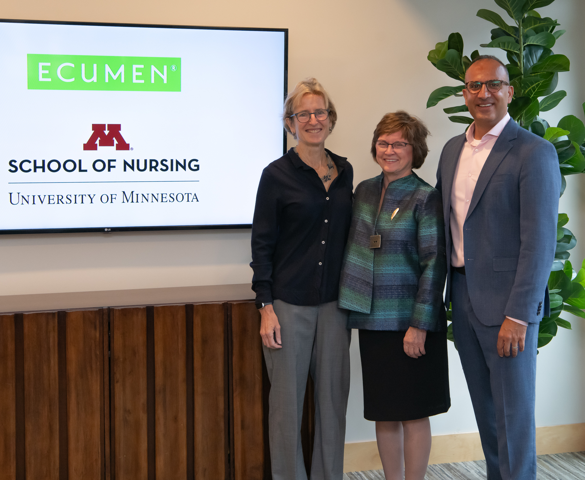Ecumen Board Chair Marcia Kull, Ecumen President & CEO Cryus Batheja and Dean Connie White Delaney holding up signed doc commemorating the partnership between Ecumen and the U of M School of Nursing