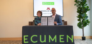 Dean Connie White Delaney and Ecumen President & CEO Cyrus Batheja holding up the signed documents commemorating the collaboratory between Ecumen and the U of M School of Nursing