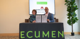Dean Connie White Delaney and Ecumen President & CEO Cyrus Batheja holding up the signed documents commemorating the collaboratory between Ecumen and the U of M School of Nursing