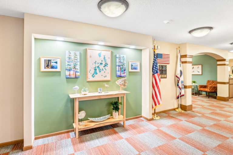 Brightly carpeted open space, featuring a map of the campus hung on the wall and an Wall of Honor with plagues and American flag.