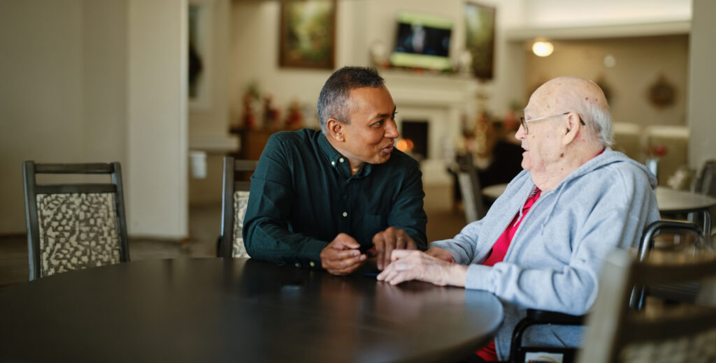 A healthcare worker attending to a senior citizen resident in a senior care living facility.