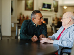 A healthcare worker attending to a senior citizen resident in a senior care living facility.