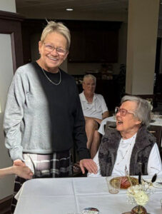 Cathy Firth of Ecumen Lakeshore smiling next to a senior female resident